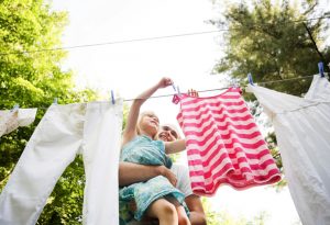 this is an image of a girl helping out with the laundry, and the active cleaning ingredients is Methyl Ester Sulphonate