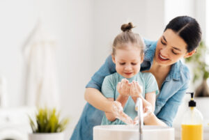 this is an image of a girl washing her hands using a hand soap that uses sympare MES that is a sustainable ingredient for personal care.